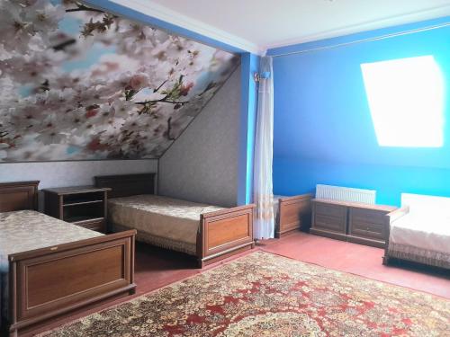 a bedroom with two beds and a painting on the wall at Guest House Sirius in Chişinău