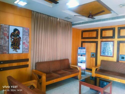a living room with a couch and a table at Hotel Mayas in Tiruchchirāppalli