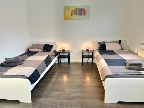 two beds in a room with two side tables at Worker Space Kleve in Kleve