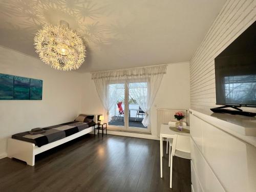 a living room with a bed and a chandelier at Worker Space Kleve in Kleve