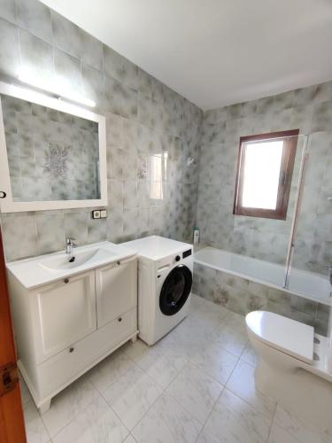 a bathroom with a sink and a washing machine at Villa with stunning sea views in Alcossebre