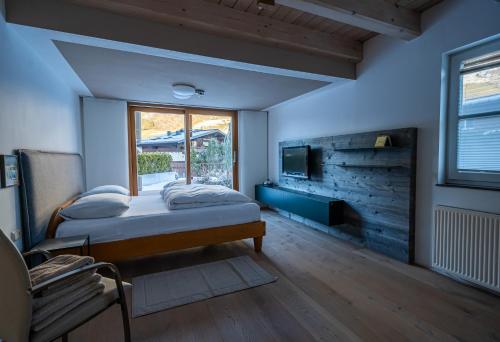 a bedroom with a bed and a tv on a wall at Chalet Sendlhofer in Bad Hofgastein