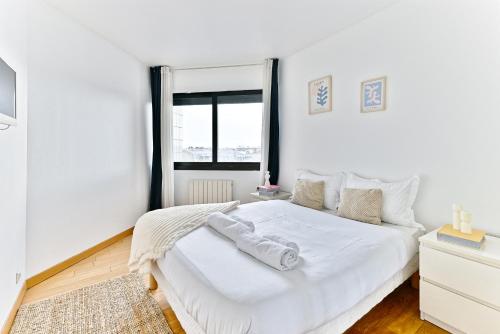 une chambre blanche avec un lit blanc et une fenêtre dans l'établissement Appartement spacieux pour un séjour inoubliable, à Paris