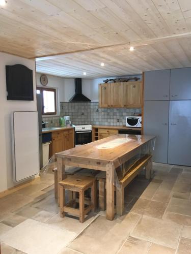 une cuisine avec une table en bois et un réfrigérateur dans l'établissement Chalet Oustalou, à Les Deux Alpes