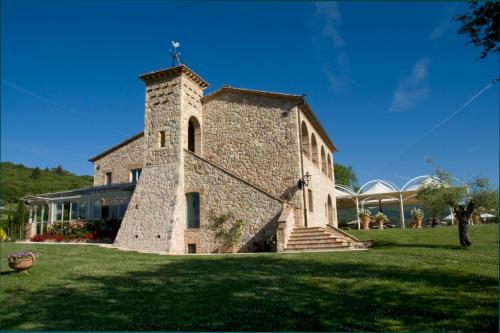 a large stone building with a tower on a field at Tenuta Del Gallo in Amelia