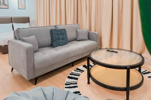a living room with a couch and a table at Taiping Rain Suite Homestay near Lake Garden with Netflix WiFi in Taiping