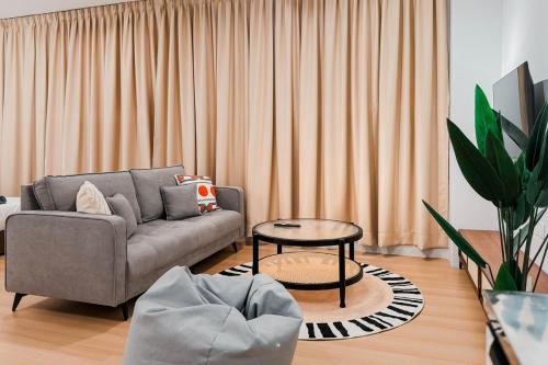 a living room with a couch and a table at Taiping Rain Suite Homestay near Lake Garden with Netflix WiFi in Taiping