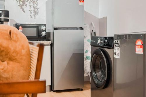 a kitchen with a refrigerator and a washing machine at Taiping Rain Suite Homestay near Lake Garden with Netflix WiFi in Taiping
