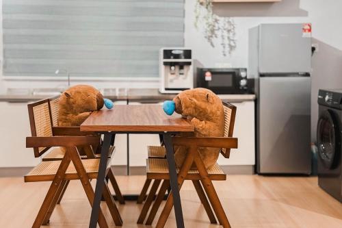two stuffed animals sitting at a table in a kitchen at Taiping Rain Suite Homestay near Lake Garden with Netflix WiFi in Taiping