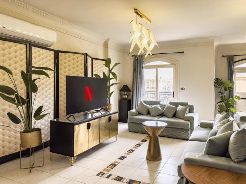 a living room with a television on a table at Cozy vintage duplex Khan -khan luxe residence pyramids view in Cairo