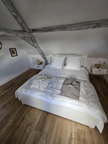 a large white bed in a room with wooden floors at EpLABONNE in Channay-sur-Lathan