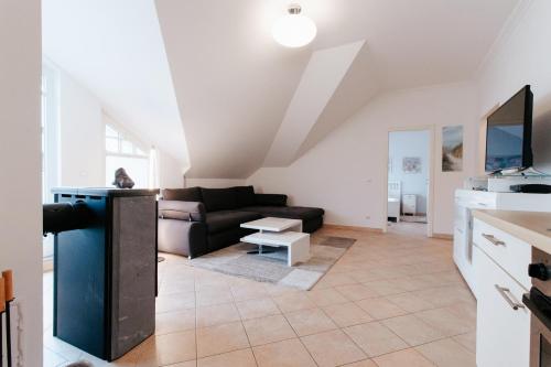 a living room with a couch and a table at Villa Laetitia Whg 24 in Binz