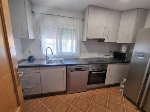 a kitchen with white cabinets and a sink at VUT EL Mogollón in Guadalajara