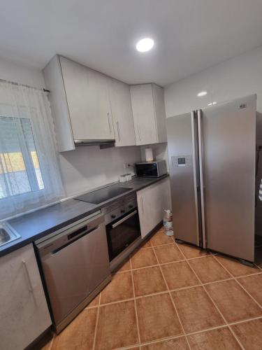 a kitchen with stainless steel appliances and white cabinets at VUT EL Mogollón in Guadalajara