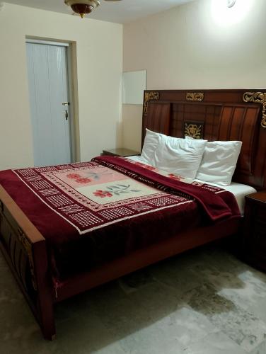 una camera da letto con un letto grande con testiera in legno di The TravelLodge Inn a Islamabad