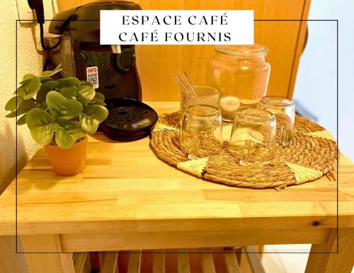 a table with glasses and a potted plant on it at Porte des remparts in Ensisheim