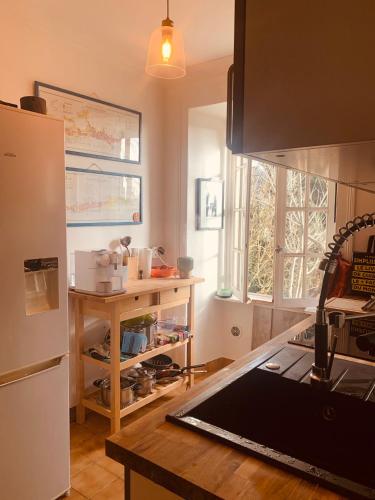 Il comprend une cuisine équipée d'un réfrigérateur et d'une table en bois. dans l'établissement Maison de famille proche St Malo, à Châteauneuf-dʼIlle-et-Vilaine