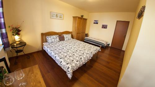 a bedroom with a bed and a wooden floor at Penzion Zatisi in Mikulov