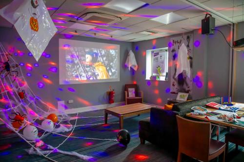 a living room with purple lights on the wall at Holiday Inn Express Royal Docks by IHG in London