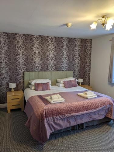 a bedroom with a bed with two towels on it at The Paddocks Hotel in Symonds Yat
