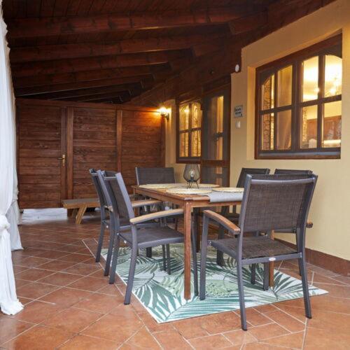 a wooden table and chairs in a room at Garden Villa Zsóry in Mezőkövesd