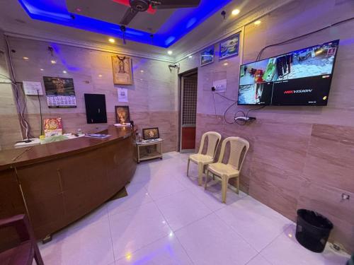 a bar with two chairs and a tv on a wall at Grand D Gala , Dharmapuri in Dharmapuri