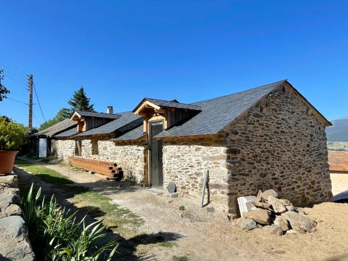 an old stone building with a slate roof at Petite et Grande Bergeries in Réal