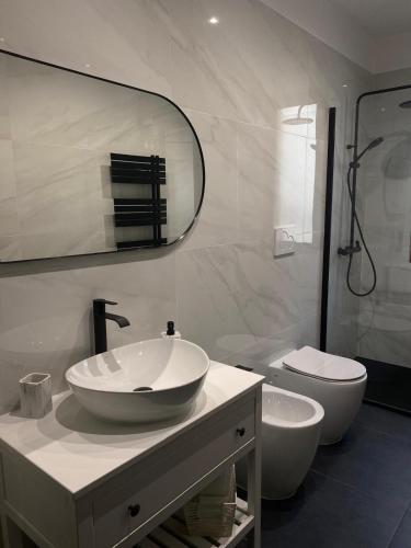 a white bathroom with a sink and a toilet at Villa Perla del Sole in Baiardo