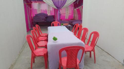 Un comedor con una mesa y sillas rojas. en TENT stay near SANGAM, en Prayagraj