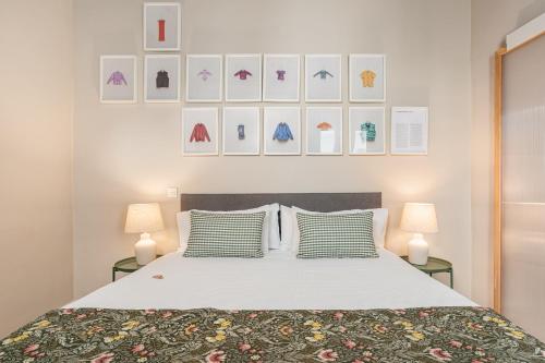 a bedroom with a bed with two lamps and pictures on the wall at Art Suites by Casa de Indias in El Puerto de Santa María