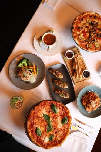 a table with plates of food on a table at Kempinski Al Othman Hotel Al Khobar in Al Khobar