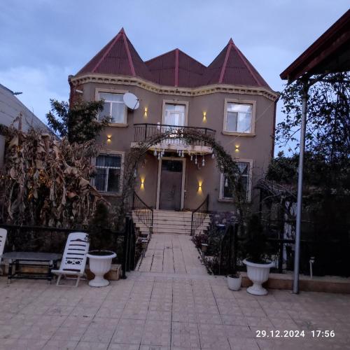 a large house with a gate and a porch at Kuki house in Ganja