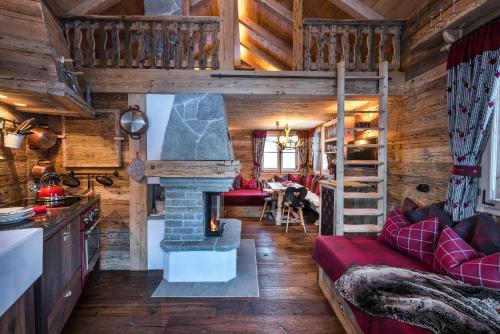 a living room with a fireplace in a log cabin at Chalet Grand Flüh - Alpiner Luxus & Spa in Nesselwängle
