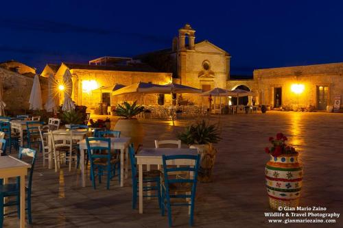 a group of tables and chairs in front of a building at Casa Marsilla in Marzamemi