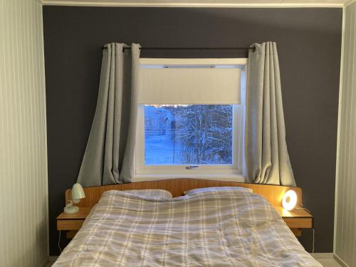 a bedroom with a bed and a window at Koselig hus ved Kabelvågmarken in Kabelvåg