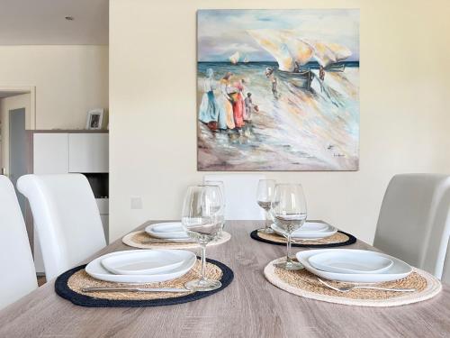 a dining room table with plates and wine glasses at Casa d'Avó in Avanca