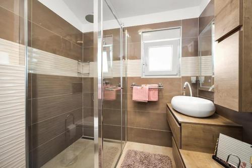 Un baño con ducha, lavabo y bañera. en House with pool and a jacuzzi, en Fažana