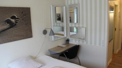 a bedroom with a desk and a mirror at Gl. Avernæs Sinatur Hotel & Konference in Ebberup