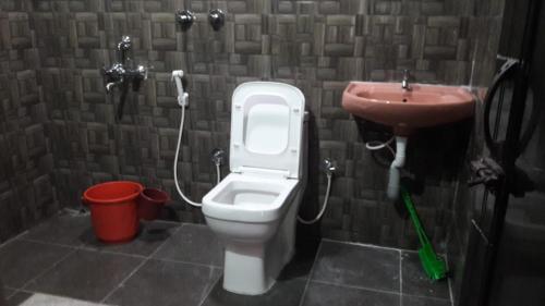 a bathroom with a toilet and a sink at Punyasiri Homestay in Suntikoppa