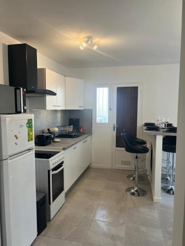 une cuisine avec un réfrigérateur blanc et une table dans l'établissement Joli T2 très bien situé, à Cagnes-sur-Mer