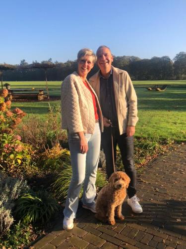 a man and a woman standing next to a dog at Domestico Bed & Breakfast in Lage Mierde