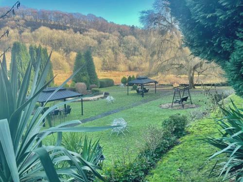 a garden with a gazebo and picnic tables at The Paddocks Hotel in Symonds Yat