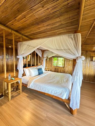 a bedroom with a bed with a canopy at Phu Chaisai Chiang Rai Mountain Resort in Mae Salong Nai