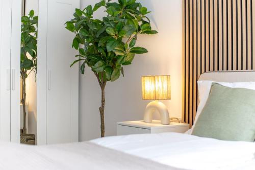 a bedroom with a bed and a plant and a lamp at Neues Ferienapartment in Neumarkt in Strimitzen