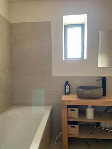 une salle de bain avec une baignoire et un lavabo dans l'établissement La bergerie cosy avec vue sur lac et montagnes, à Réal