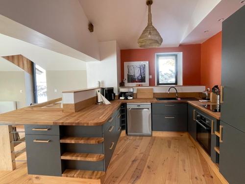 une cuisine avec un grand îlot et des comptoirs en bois dans l'établissement La bergerie cosy avec vue sur lac et montagnes, à Réal