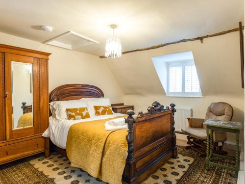 a bedroom with a large bed and a chair at Riverside Manor in Offenham