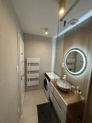 a bathroom with a sink and a washing machine at Mountain Heim Apartment in Poprad
