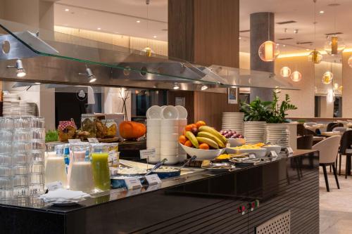 a buffet line in a restaurant with fruit and drinks at Wyndham Wroclaw Old Town in Wrocław