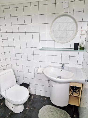 a white bathroom with a toilet and a sink at 1C, Första parkett, 50m till badstrand in Byxelkrok